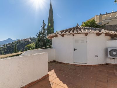 Terrasse carrelée de terre cuite avec un charmant bâtiment annexe au toit de tuiles traditionnelles. Offre des vues étendues sur les collines verdoyantes et les montagnes lointaines.
