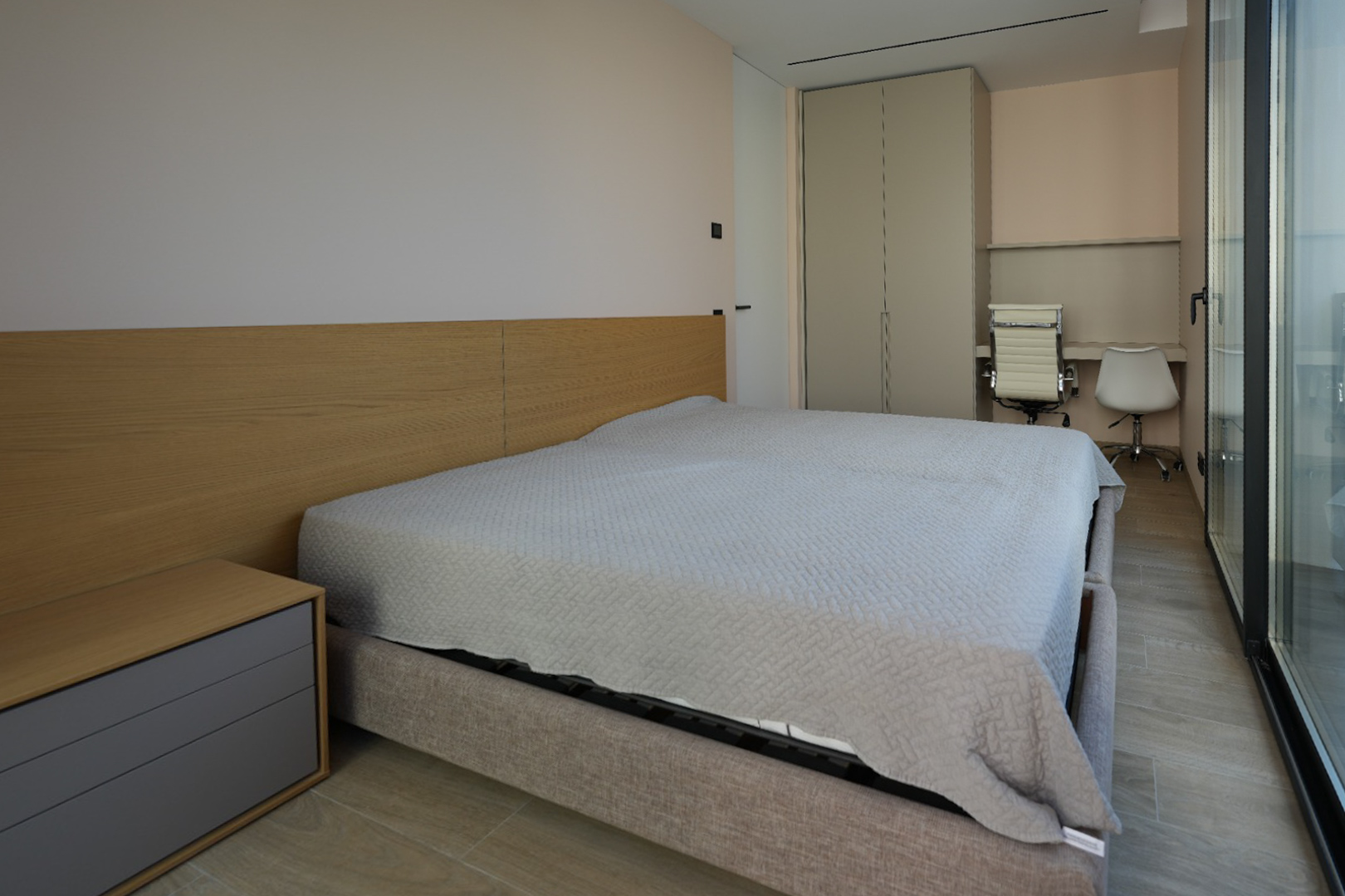 Chambre moderne avec lit capitonné gris clair, tête de lit en bois et table de chevet intégrée. Elle comprend une armoire encastrée, un double espace bureau et de grandes baies vitrées. Chambre moderne avec lit capitonné gris clair, tête de lit en bois et table de chevet intégrée. Elle comprend une armoire encastrée, un double espace bureau et de grandes baies vitrées.