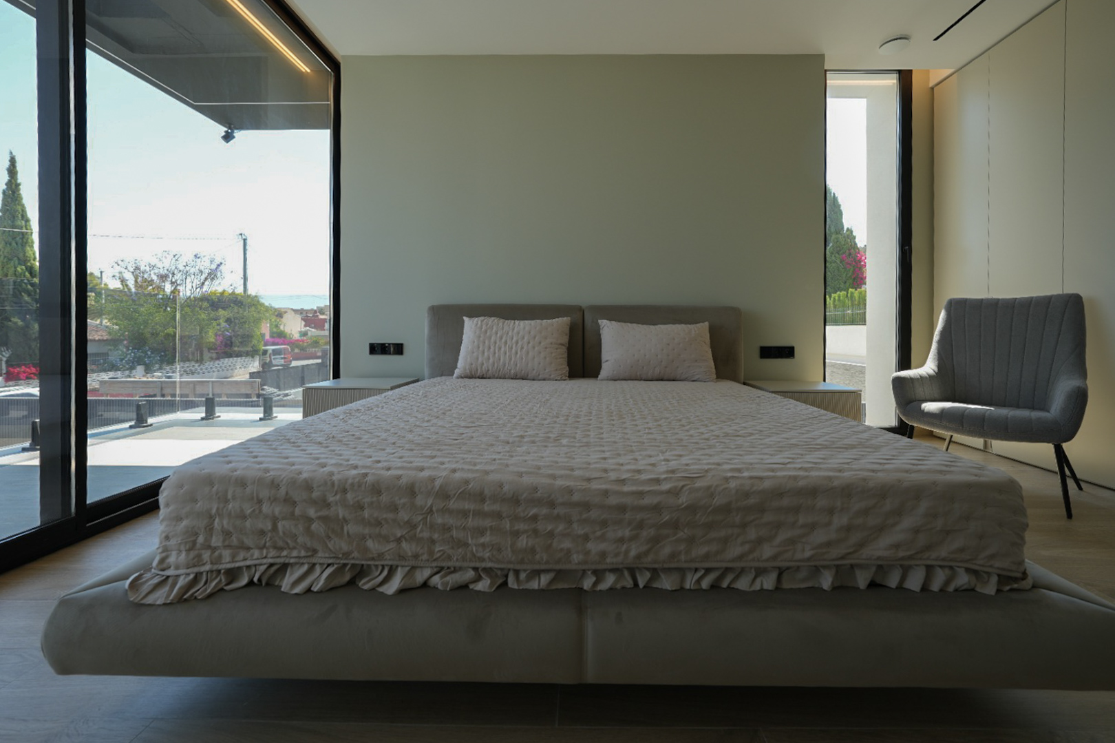 Chambre principale avec lit flottant, tête de lit rembourrée, grandes fenêtres avec vue sur la mer et fauteuil. Tables de chevet intégrées. Chambre principale avec lit flottant, tête de lit rembourrée, grandes fenêtres avec vue sur la mer et fauteuil. Tables de chevet intégrées.