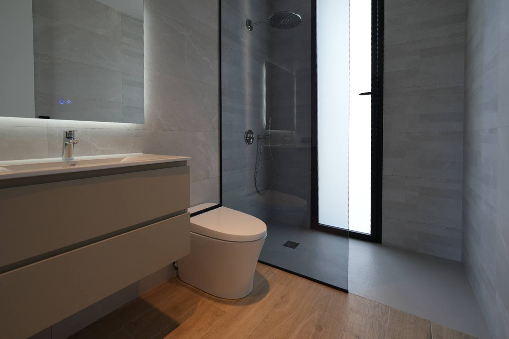Salle de bain contemporaine avec meuble-lavabo suspendu, miroir éclairé, WC mural et douche à l'italienne avec pommeau pluie, murs carrelés gris et sol effet bois. Salle de bain contemporaine avec meuble-lavabo suspendu, miroir éclairé, WC mural et douche à l'italienne avec pommeau pluie, murs carrelés gris et sol effet bois.