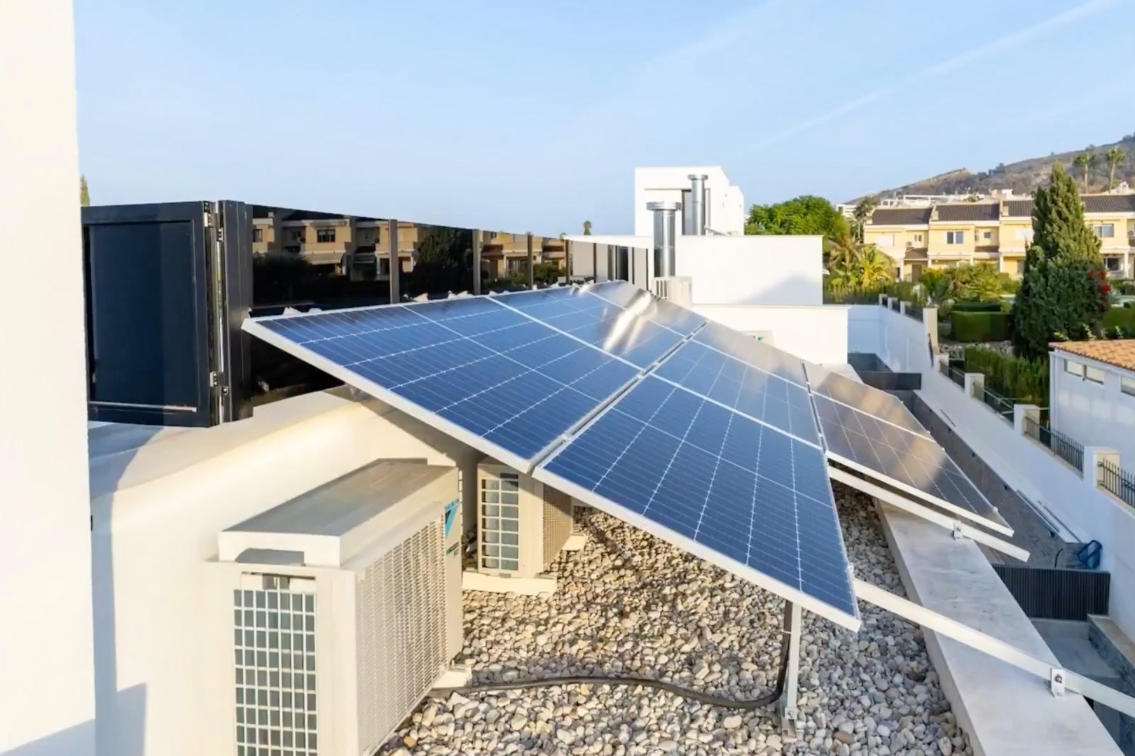 Vaste système de panneaux solaires photovoltaïques sur le toit. Les unités de climatisation et une surface de gravier clair complètent cette installation à haute efficacité. Vaste système de panneaux solaires photovoltaïques sur le toit. Les unités de climatisation et une surface de gravier clair complètent cette installation à haute efficacité.