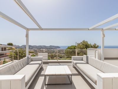 Solarium sur le toit avec pergola blanche, deux canapés d'extérieur confortables et une table basse, offrant des vues panoramiques sur la mer Méditerranée et la côte.