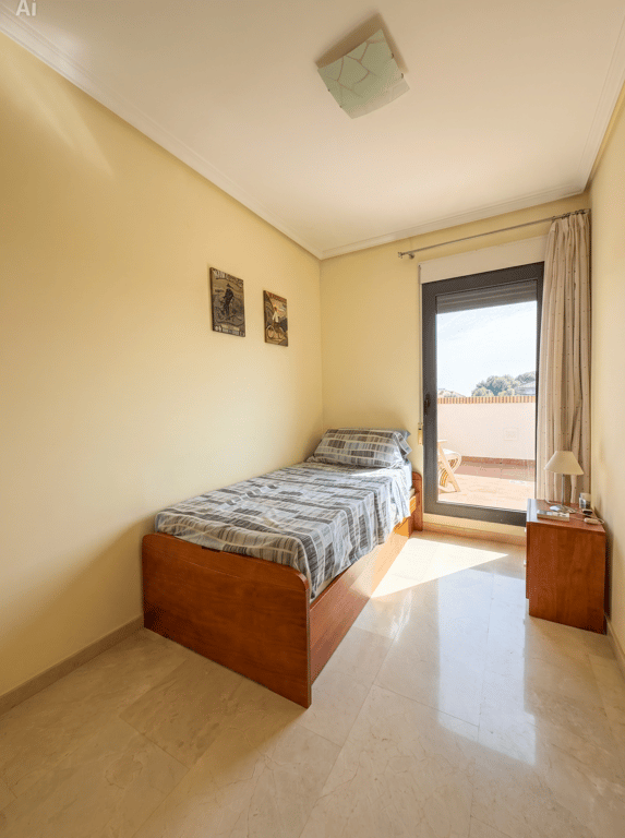 Chambre individuelle avec lit en bois, sol en marbre poli et accès direct à une terrasse supérieure, baignée de lumière naturelle.