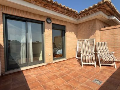 Vaste terrasse supérieure avec carrelage en terre cuite, murs en briques et tuiles traditionnelles. Meublée de deux chaises longues et accès direct aux chambres.