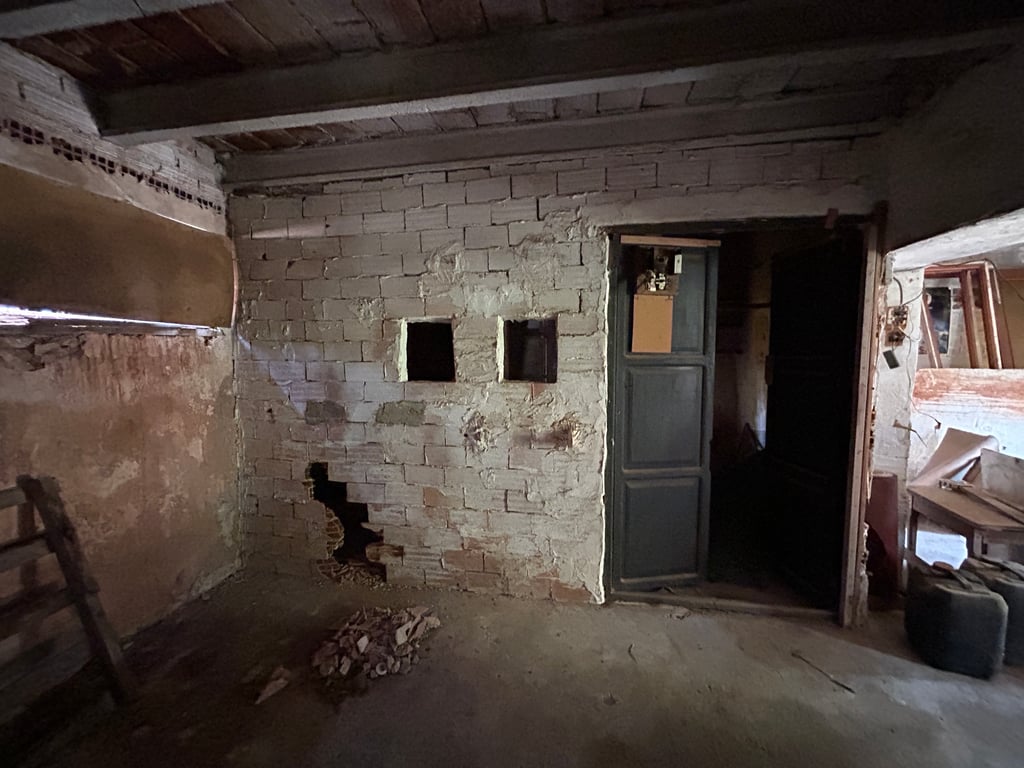 Intérieur brut avec murs en briques apparentes, plafond à poutres en bois et ouvertures. Un espace clair offrant un potentiel de rénovation complète. Intérieur brut avec murs en briques apparentes, plafond à poutres en bois et ouvertures. Un espace clair offrant un potentiel de rénovation complète.