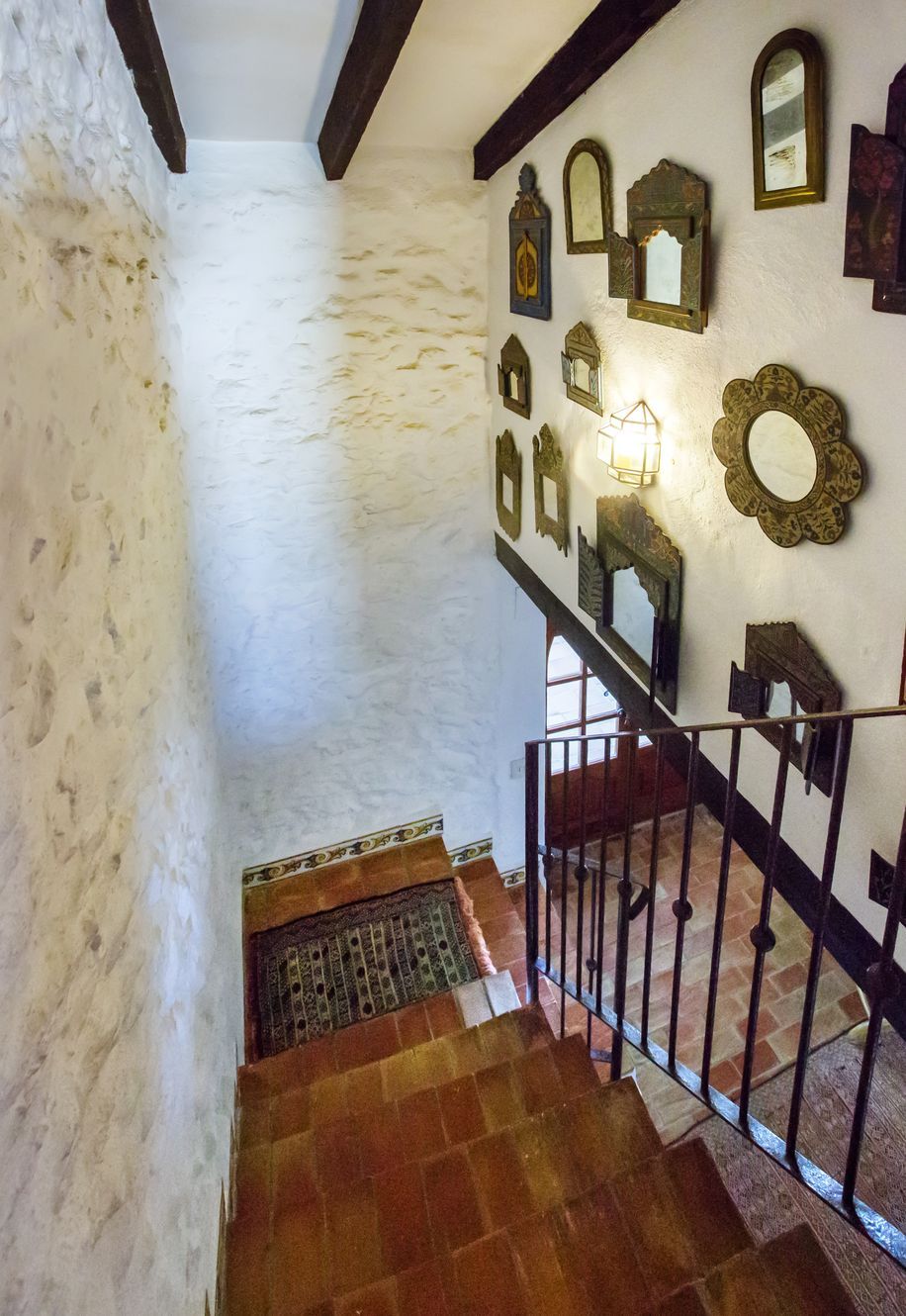 Détail de l'escalier avec marches en terre cuite et mur orné de miroirs rustiques à Teulada.