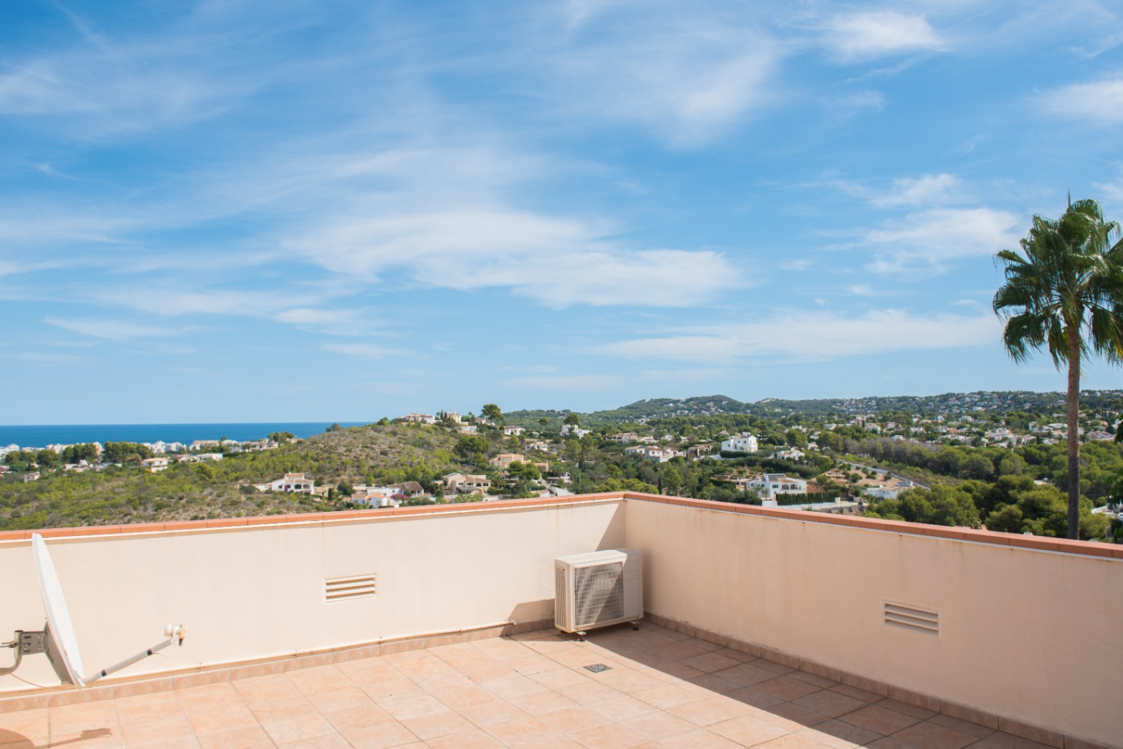 Terrasse sur le toit avec carrelage en terre cuite offrant une vue panoramique sur le littoral méditerranéen, les collines et les quartiers résidentiels.