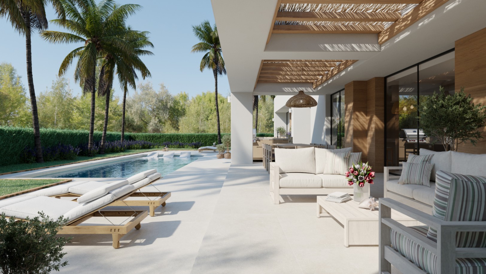 Terrasse extérieure avec pergola en bois, coin salon avec canapés blancs et piscine entourée de palmiers et d'une haie verdoyante.
