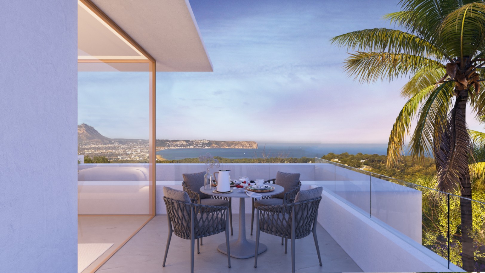 Terrasse avec vue panoramique sur la mer et les montagnes, comprenant un coin repas avec chaises tressées et garde-corps en verre.