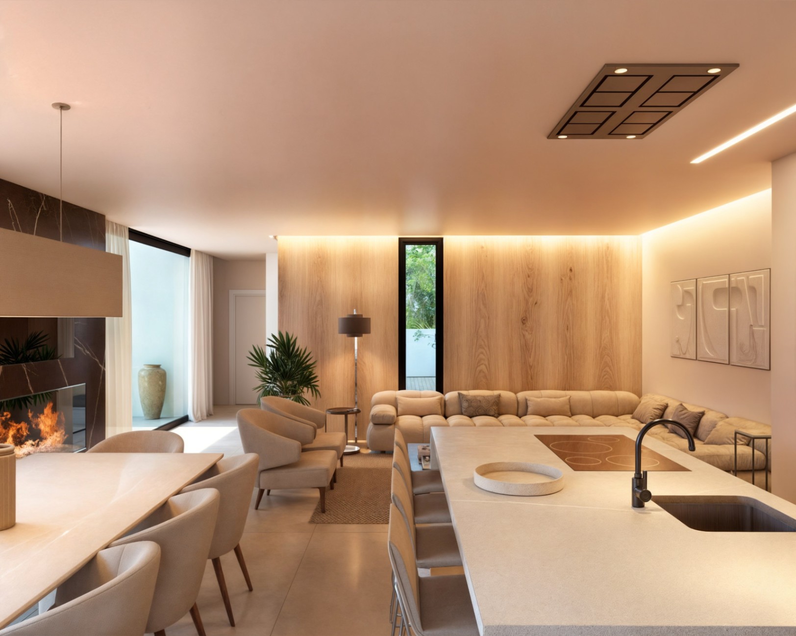 Espace de vie ouvert comprenant un îlot de cuisine en pierre, une salle à manger avec cheminée en marbre et un salon aux murs boisés avec éclairage indirect.