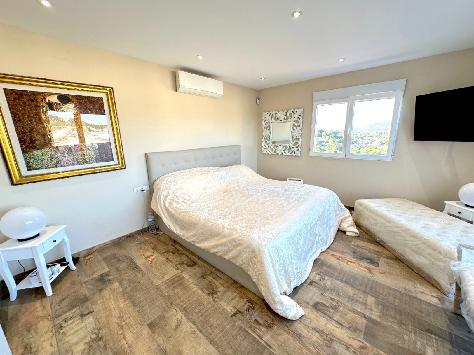 Chambre avec sol en céramique imitation bois, climatisation et vue sur la vallée. Comprend un éclairage LED encastré et une tête de lit rembourrée moderne.