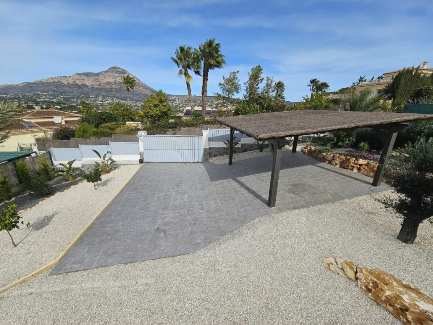 Entrée de la villa avec portail électrique, parking couvert avec pergola et vue sur le Montgó.
