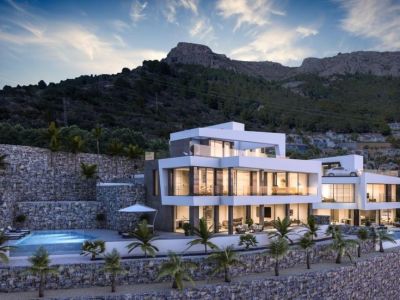 Vue extérieure de la villa avec piscine à débordement et façade en pierre naturelle.