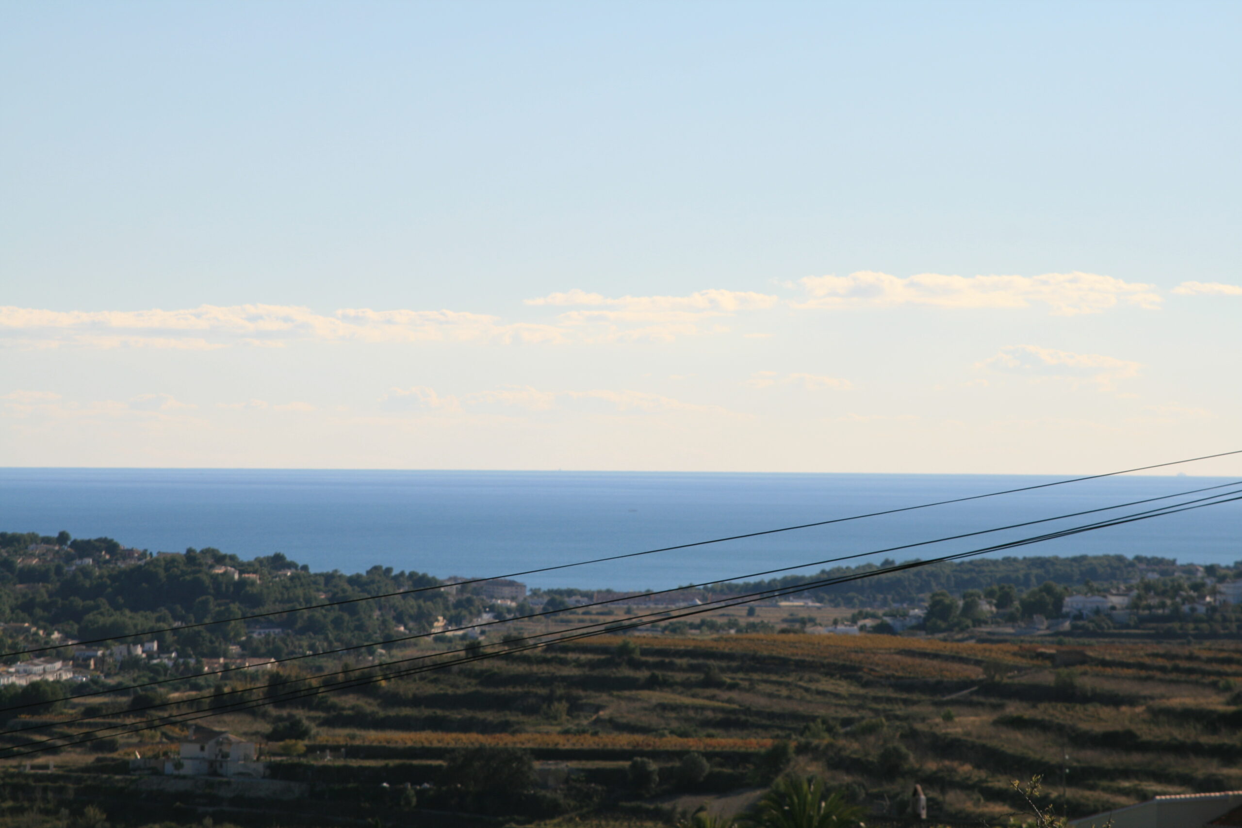 Vue du terrain avec la mer Méditerranée en arrière-plan, mettant en valeur son emplacement et son potentiel paysager.