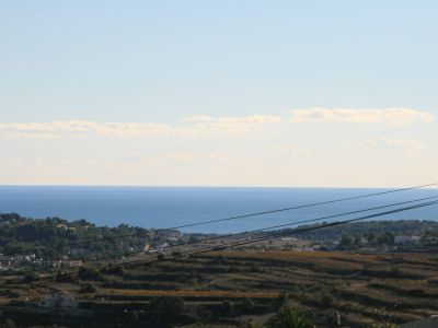Vue du terrain avec la mer Méditerranée en arrière-plan, mettant en valeur son emplacement et son potentiel paysager.
