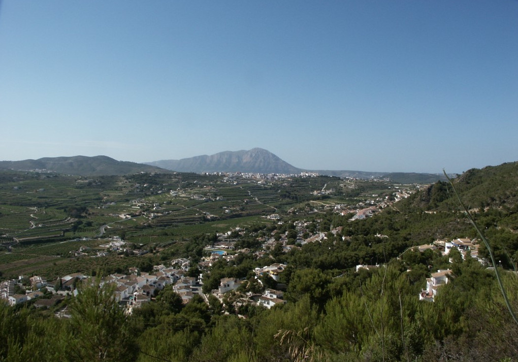 Vue panoramique de Benitachell avec terrasses agricoles et le Montgó en arrière-plan.