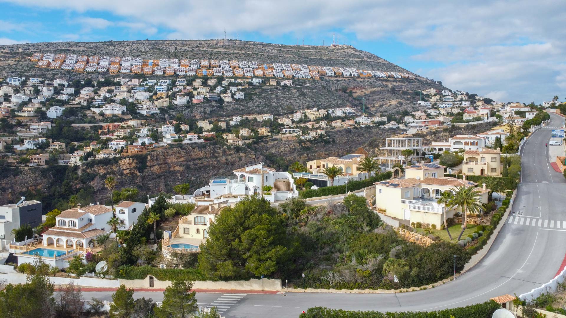 Vue aérienne panoramique du quartier résidentiel de Cumbre del Sol, illustrant la disposition des villas sur la colline et le paysage méditerranéen.