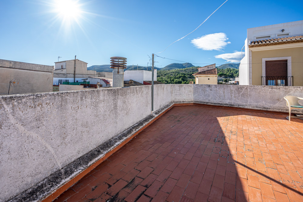 Terrasse sur le toit avec revêtement en terre cuite offrant une vue dégagée sur les montagnes environnantes et le paysage naturel.