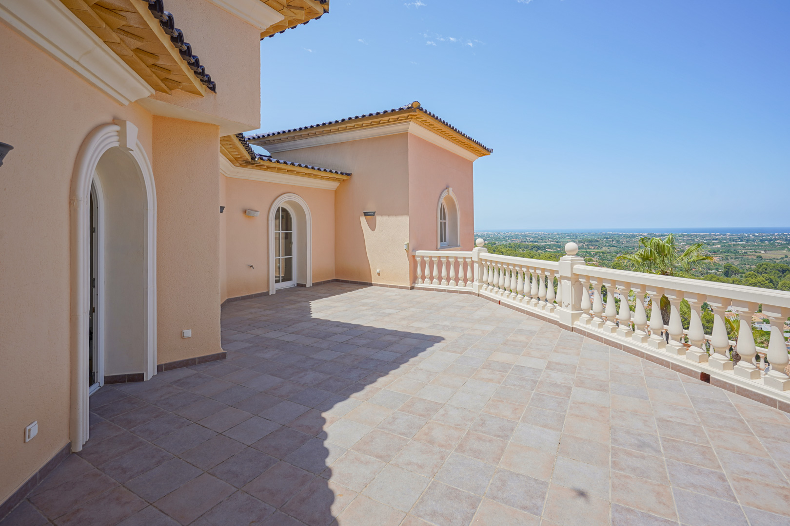 Grande terrasse à l'étage avec sol en grès, balustrade classique et vue panoramique imprenable sur la vallée et la mer Méditerranée.