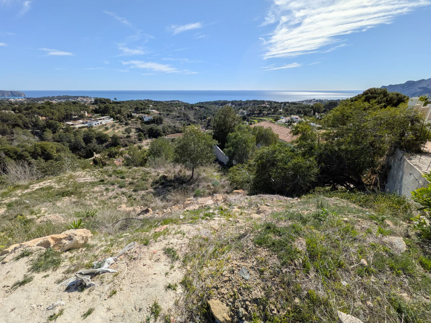 Vue panoramique depuis le terrain en pente sur la mer Méditerranée, illustrant le relief escarpé et la végétation environnante de Benissa.