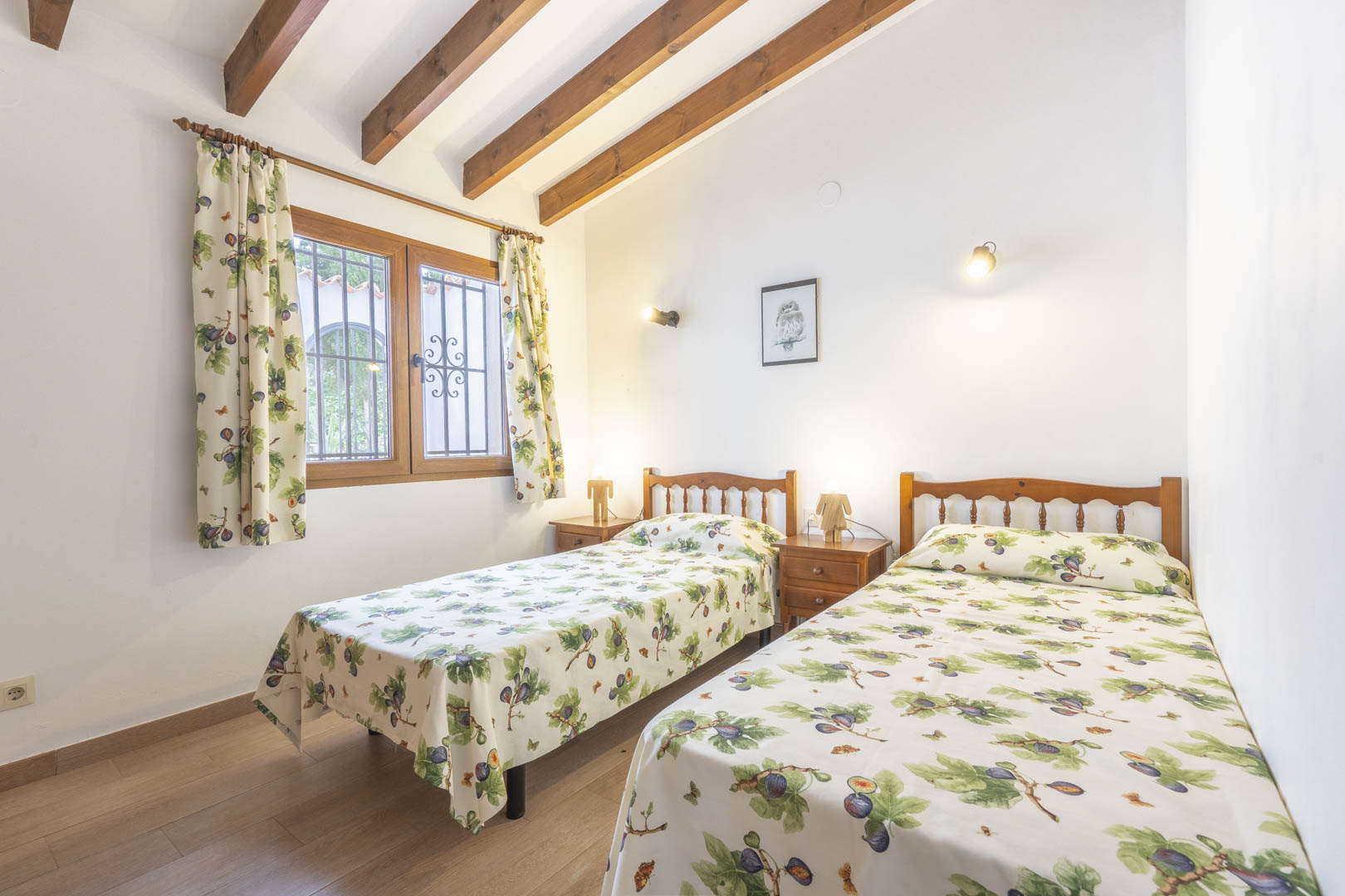 Chambre avec lits jumeaux, poutres apparentes et décoration traditionnelle.