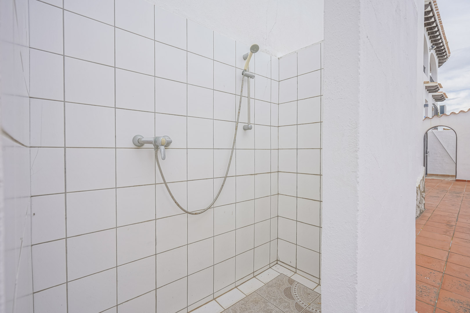Douche extérieure avec carrelage blanc et sol décoratif dans villa à Monte Pego.