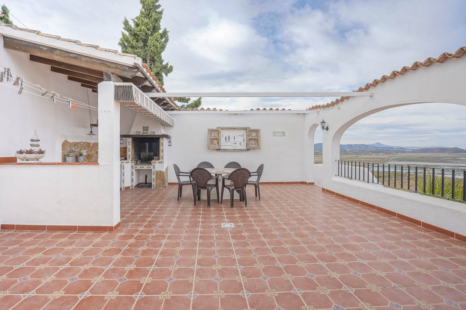 Terrasse avec barbecue et vue panoramique dans villa à Monte Pego. Sols carrelés et mobilier extérieur.