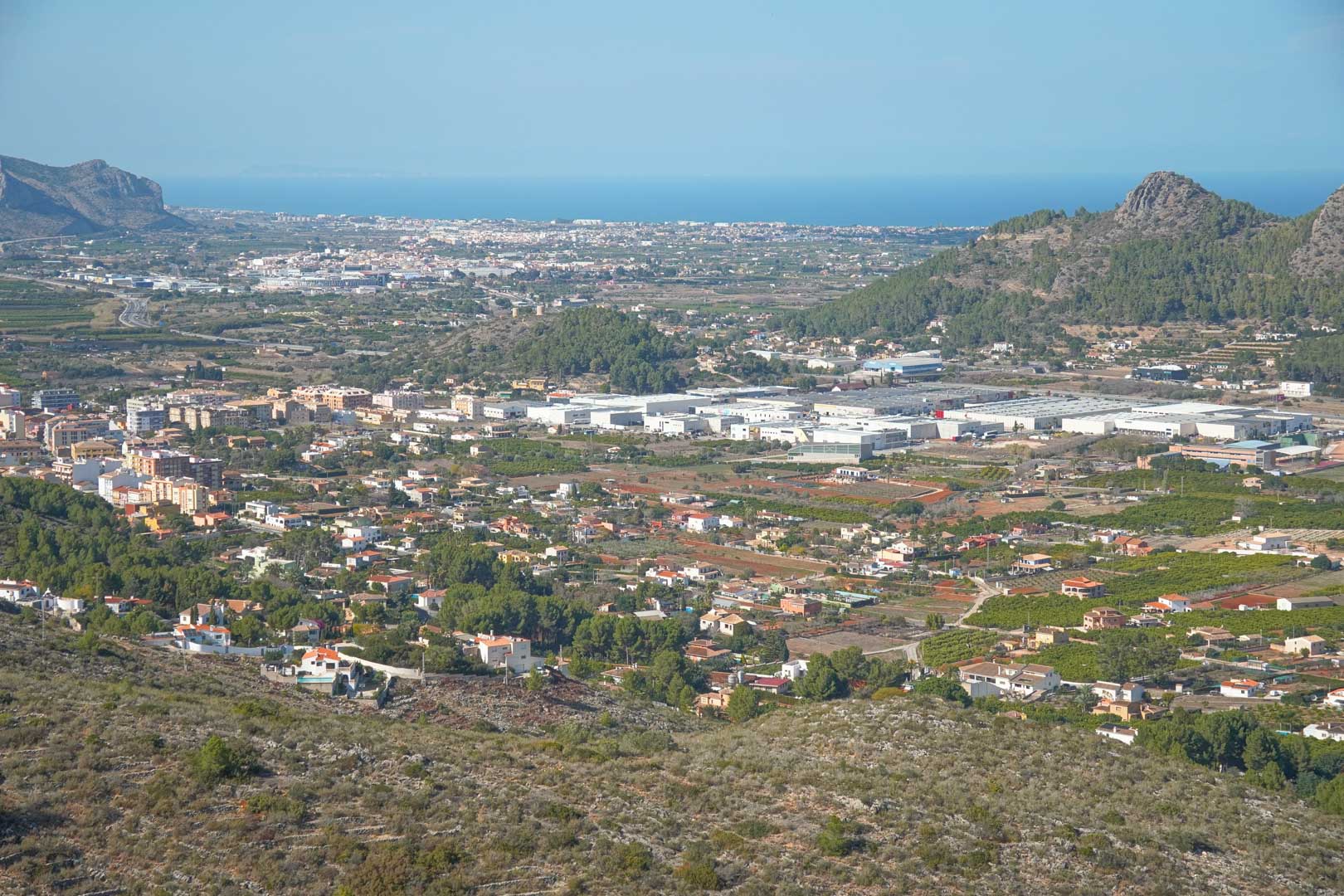 Vues panoramiques depuis la propriété sur la vallée de Pedreguer, révélant le paysage urbain et la mer Méditerranée à l'horizon par temps clair.