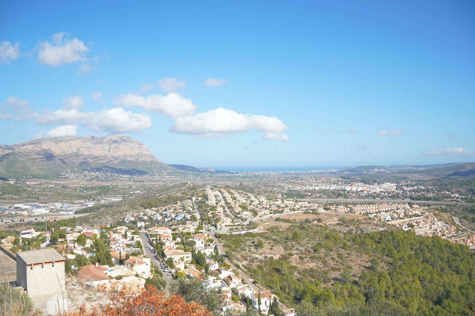 Vues panoramiques sur la vallée de Pedreguer et le massif du Montgó, avec la mer Méditerranée se dessinant à l'horizon sous un ciel dégagé.