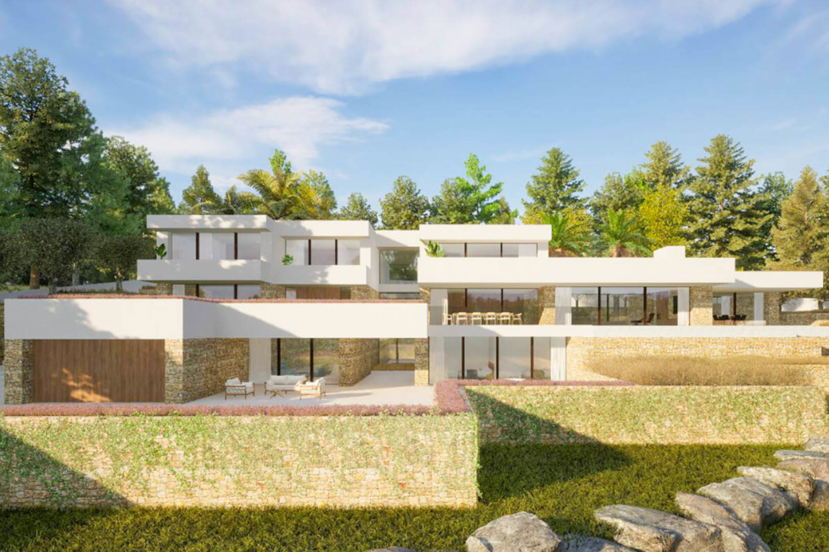 Façade extérieure de la villa à l'architecture de style ibizien, alliant murs en pierre naturelle, grandes baies vitrées et terrasses intégrées dans un jardin méditerranéen.