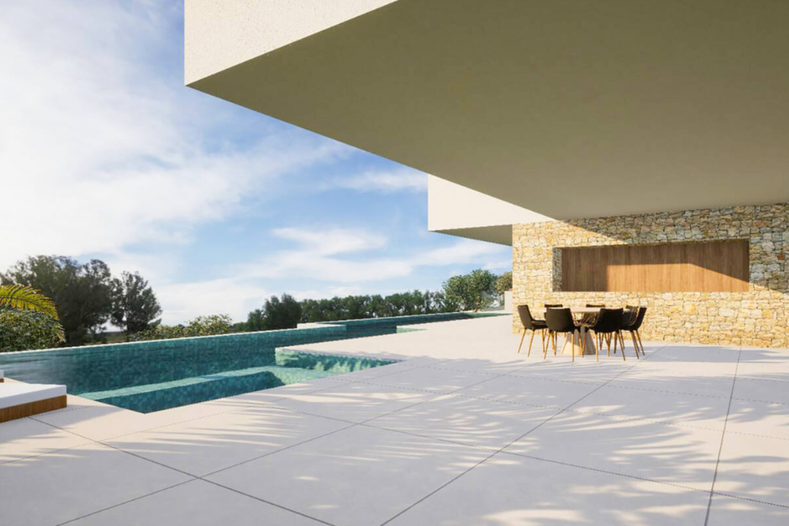 Terrasse extérieure avec carrelage grand format, espace dînatoire ombragé sous porte-à-faux et piscine à débordement bordée d'un mur en pierre naturelle.