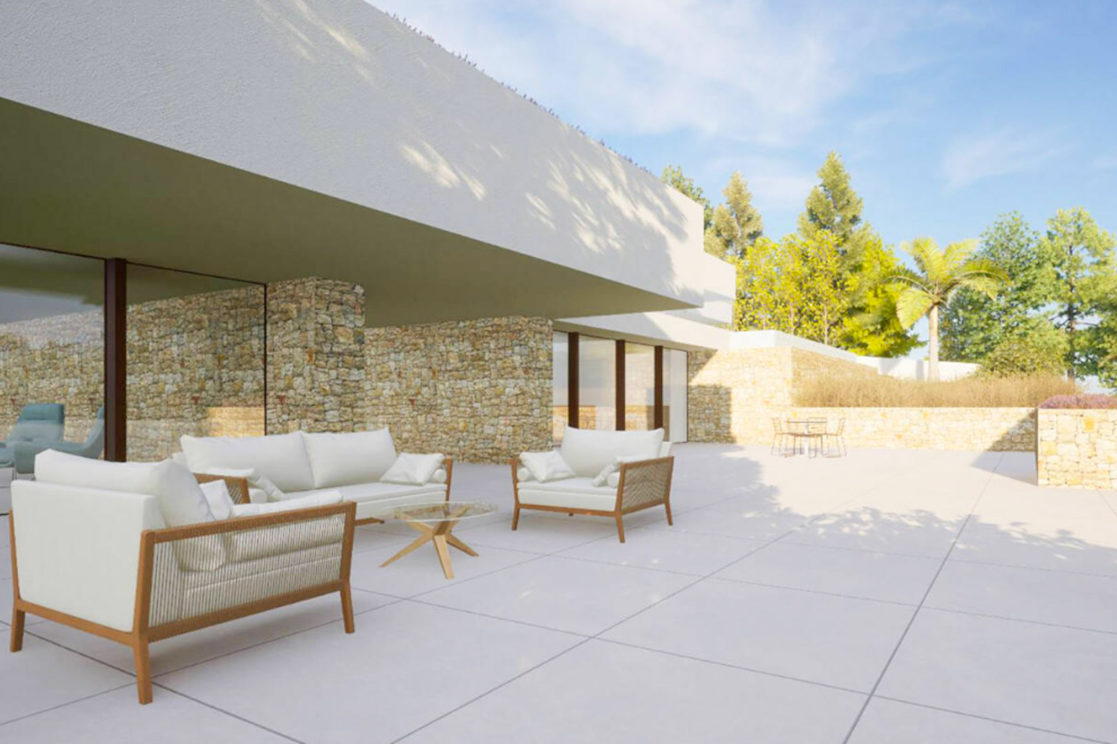 Terrasse extérieure avec mobilier élégant, murs en pierre naturelle et grandes baies vitrées s'ouvrant sur un jardin méditerranéen ensoleillé.