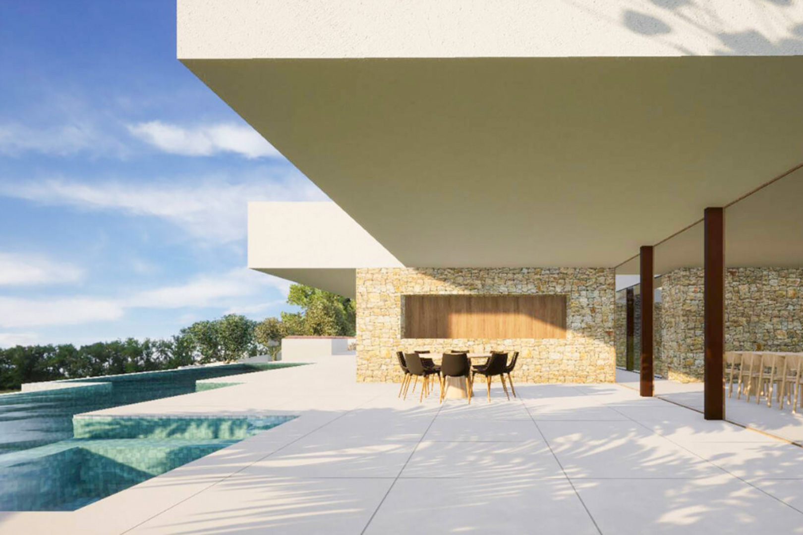 Terrasse extérieure avec murs en pierre naturelle, carrelage grand format et coin repas ombragé sous un porte-à-faux moderne, bordant la piscine à débordement.