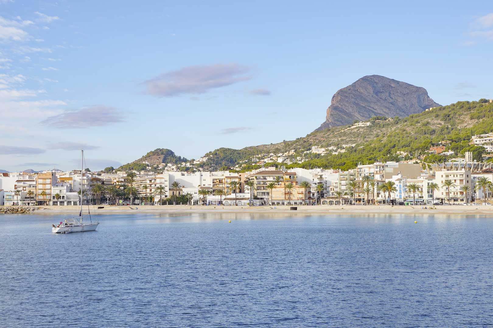 Vue panoramique de la baie de Jávea avec le mont Montgó en arrière-plan, illustrant le cadre côtier et la proximité immédiate de la mer.