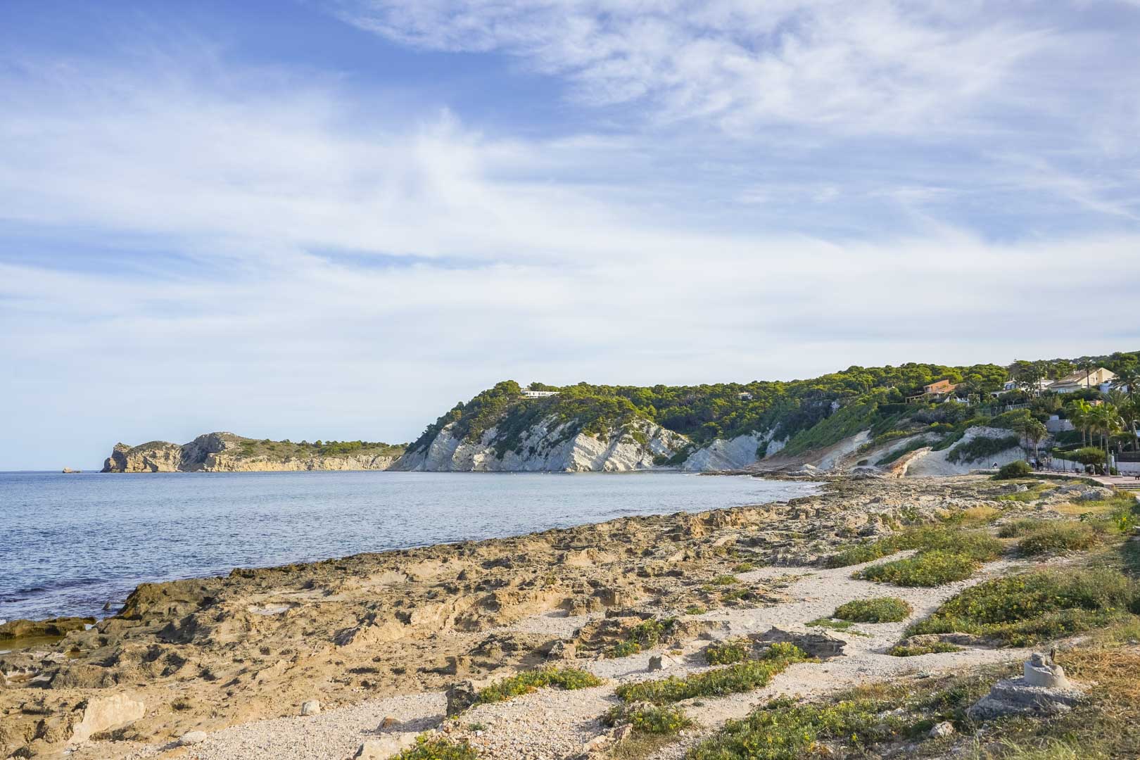 Vue panoramique de la côte rocheuse de Jávea, avec des falaises de calcaire et le rivage méditerranéen sous un ciel dégagé.