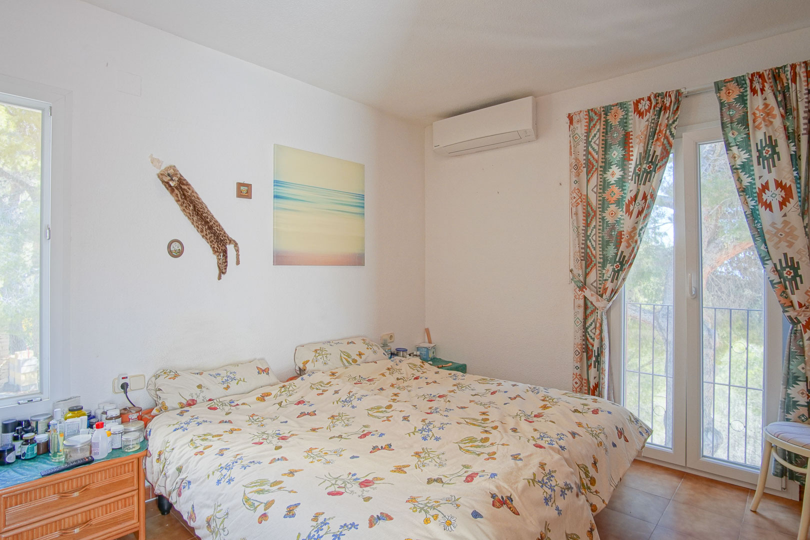 Chambre lumineuse avec climatisation réversible, accès direct à la terrasse par une porte vitrée et sol en grès cérame.