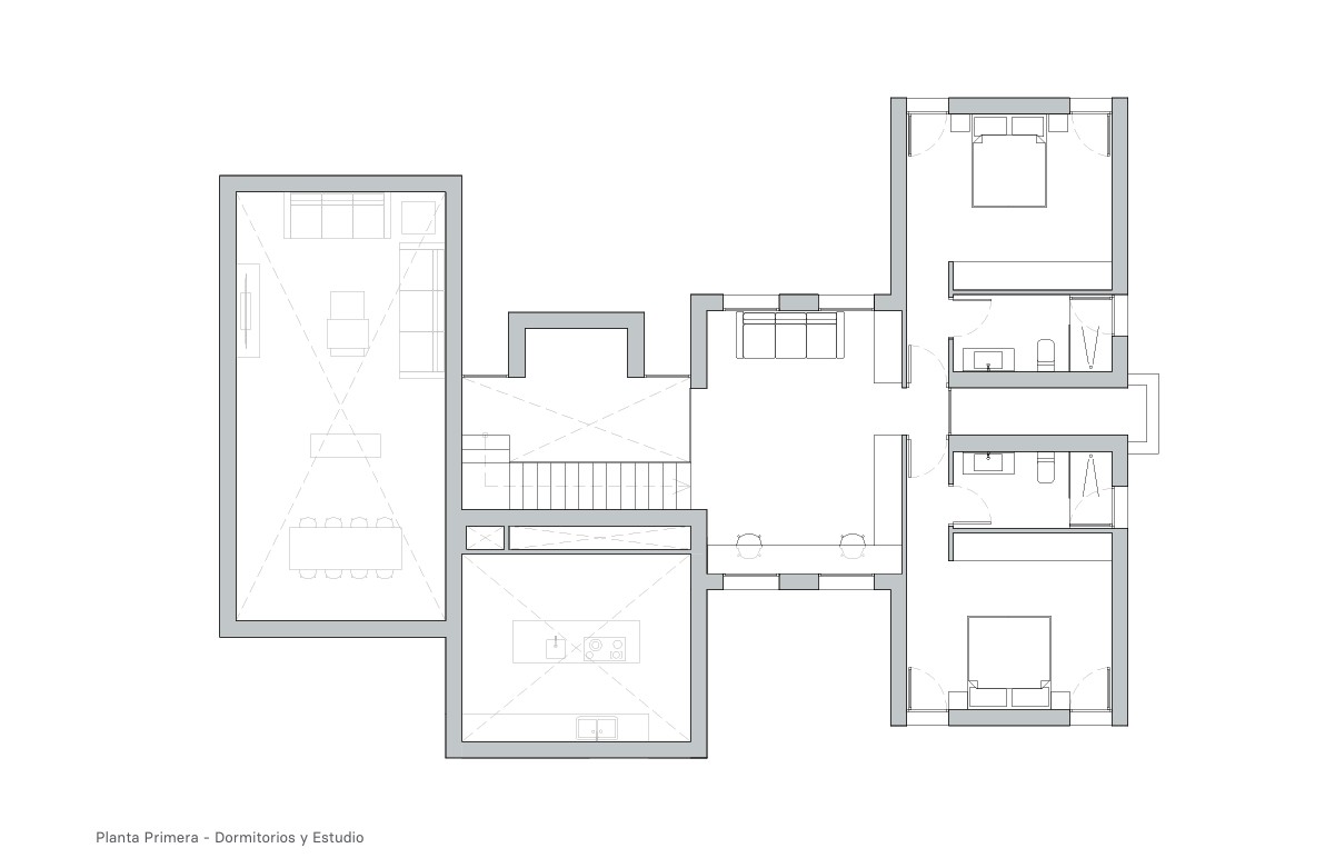 Plan architectural du premier étage comprenant deux chambres doubles avec salles de bains privatives et un bureau central surplombant le séjour.