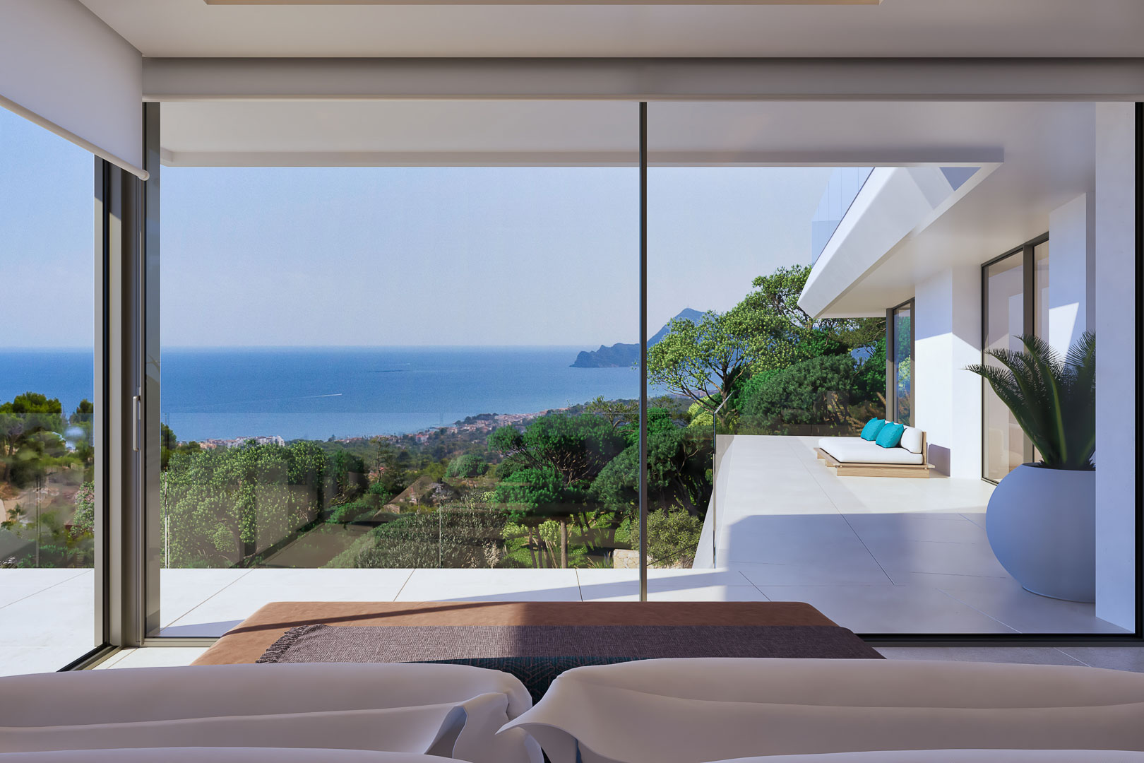 Chambre principale avec baies vitrées toute hauteur offrant une vue panoramique sur la mer et un accès direct à une terrasse privée avec mobilier de détente.