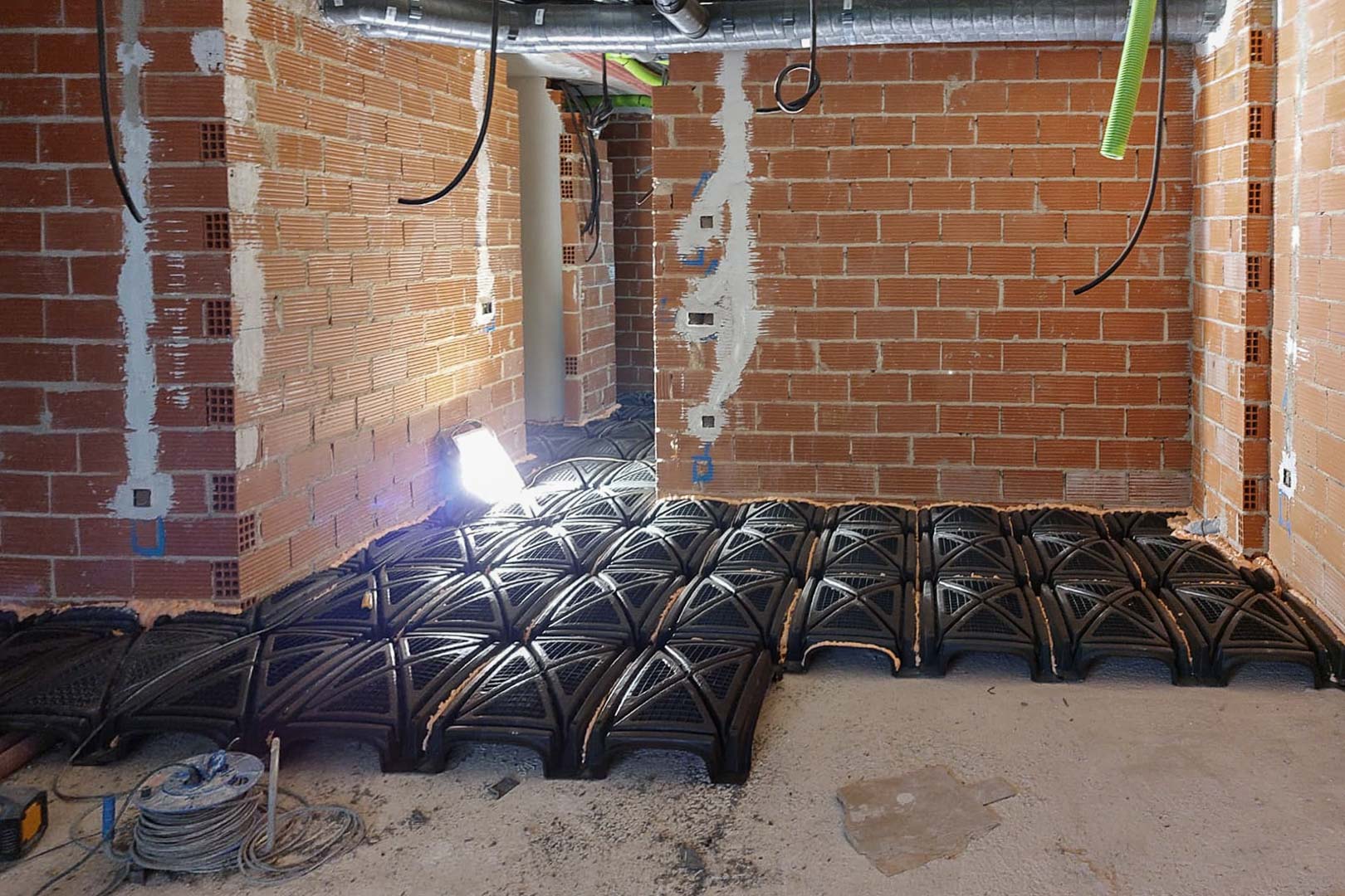 Phase de construction montrant l'installation d'un vide sanitaire ventilé avec des modules en polypropylène pour une isolation structurelle optimale.