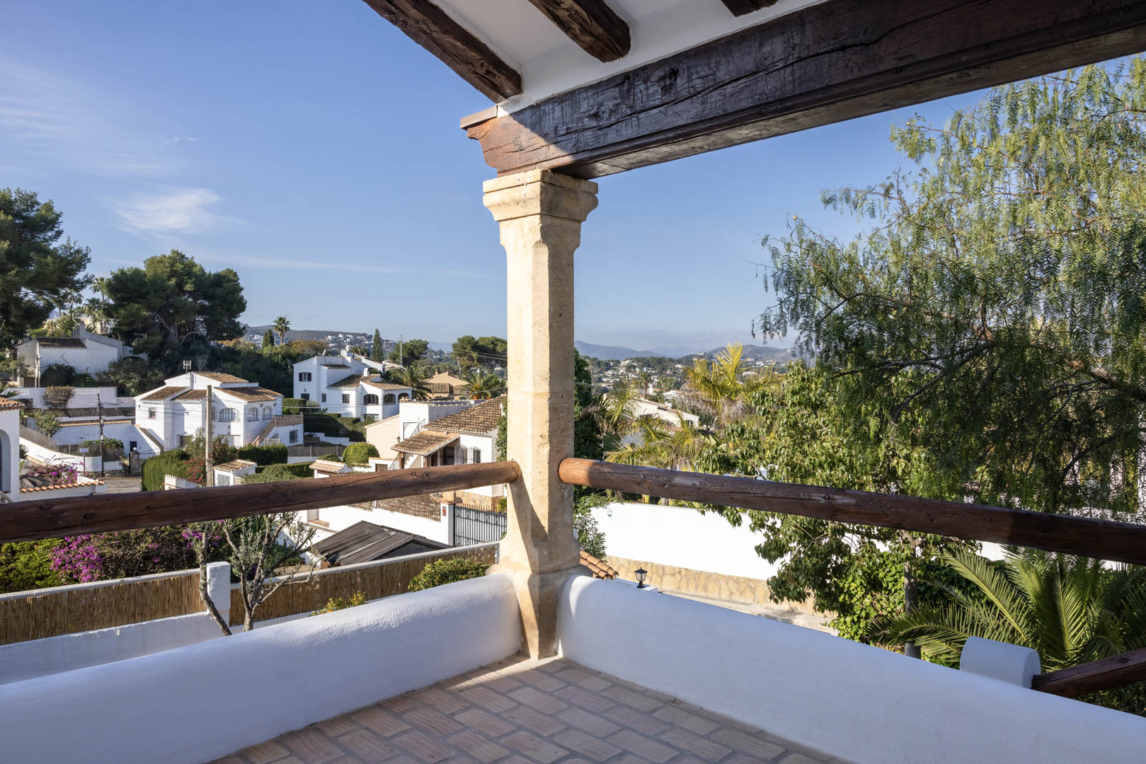Terrasse avec vue à Tosalet, Jávea. Détails rustiques : poutres en bois et sol carrelé.