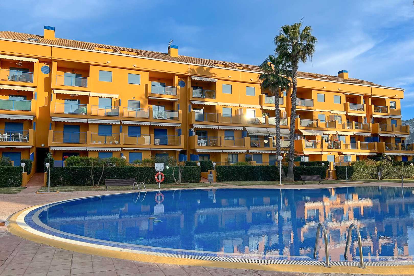 Vue extérieure de la piscine commune et façade de l'immeuble résidentiel à Dénia.