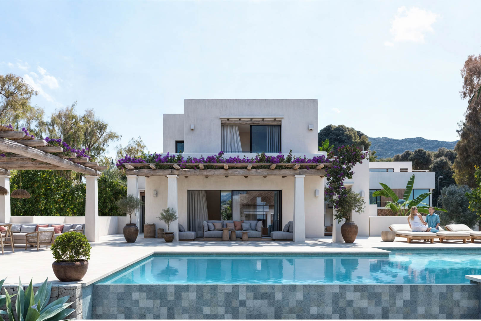 Vue extérieure de la villa avec piscine en mosaïque, pergola en bois avec glycine et façade blanche.