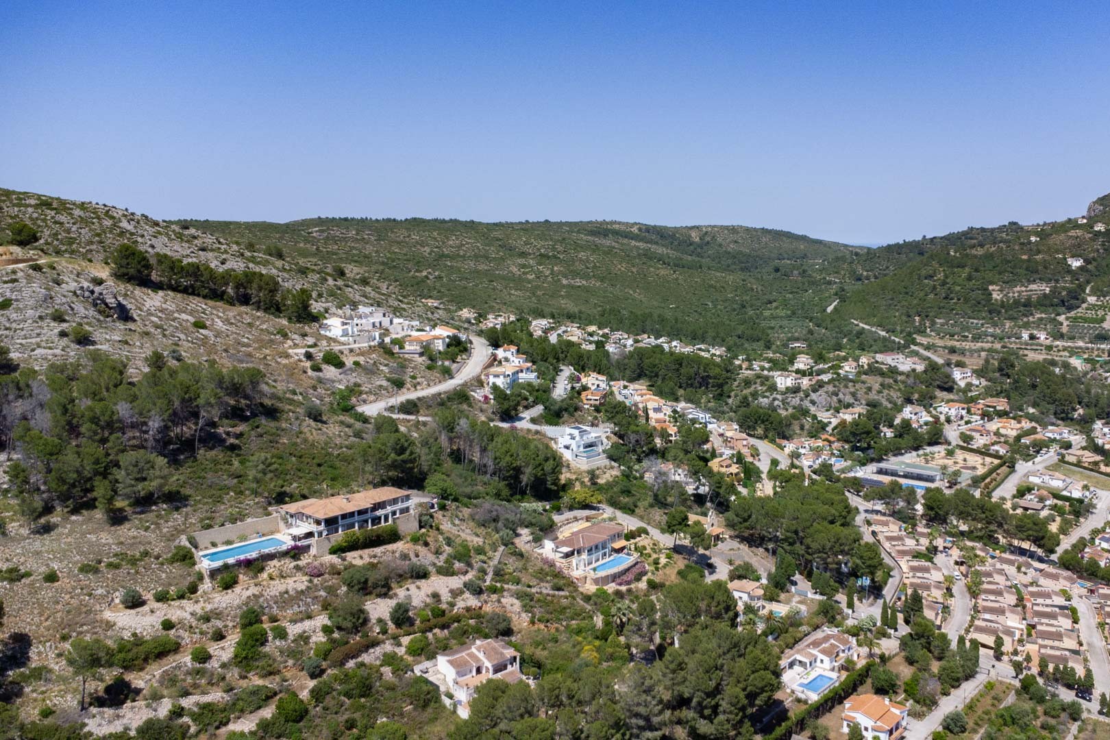Vue aérienne panoramique du quartier résidentiel VALL DE POP à Alcalalí, illustrant l'emplacement surélevé des parcelles au cœur des paysages naturels de la vallée de Jalón.
