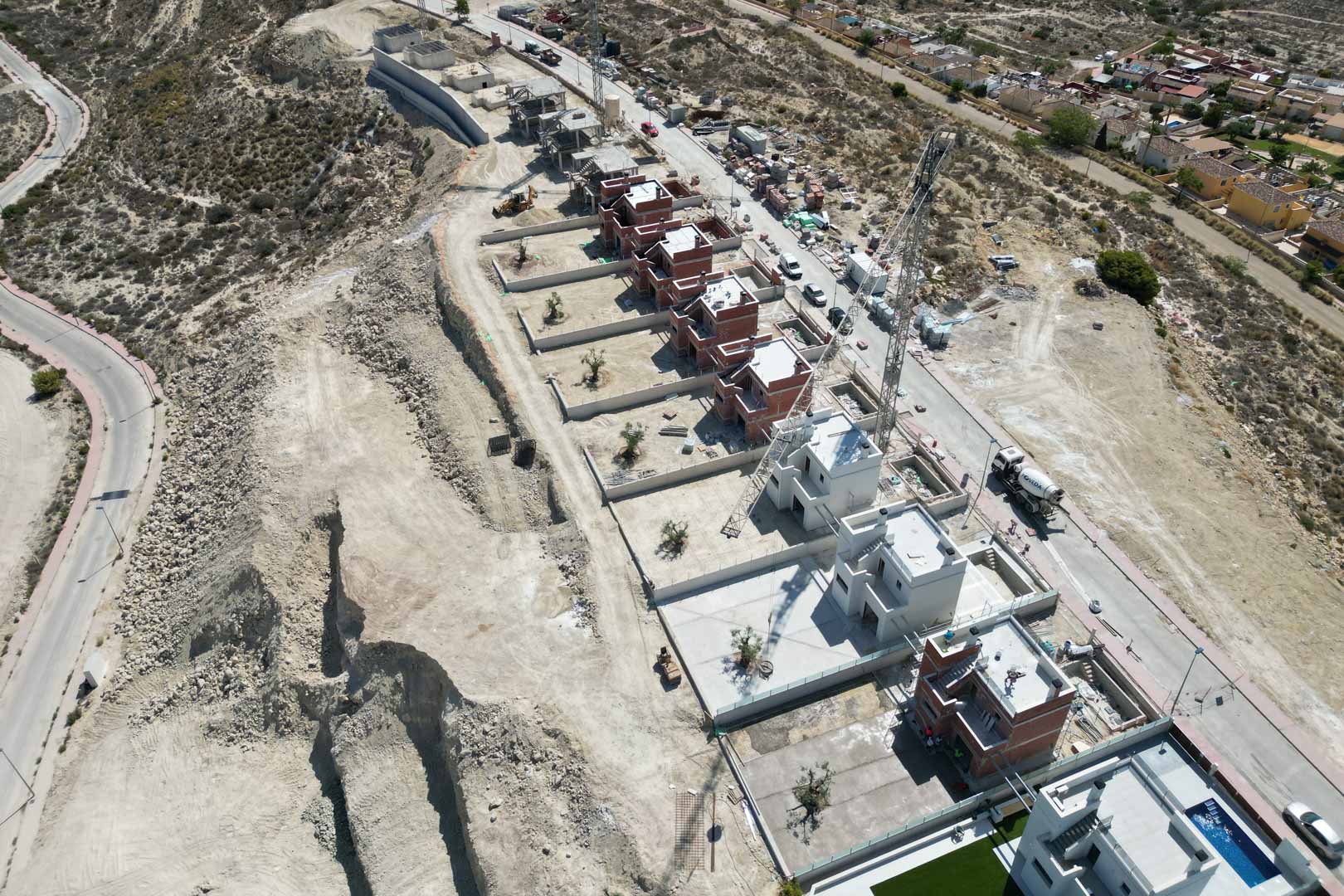 Vue aérienne du complexe de villas en cours de construction, illustrant l'emplacement surélevé et l'agencement des structures de style contemporain.