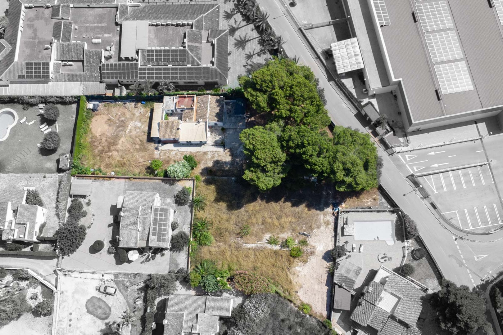 Vue aérienne de la parcelle de 2 600 m² illustrant la villa actuelle, les pins matures et l'intégration du terrain dans son environnement urbain proche des commodités.