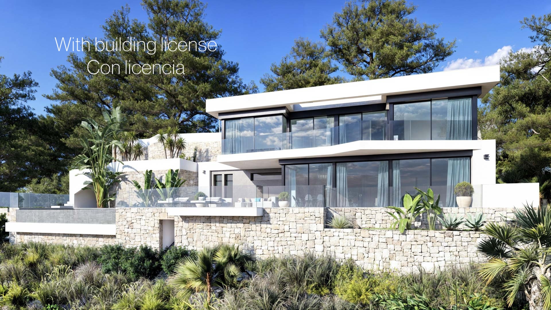 Façade moderne sur deux niveaux avec murs en pierre naturelle, grandes baies vitrées et garde-corps en verre, intégrée dans un paysage méditerranéen bordé de pins.