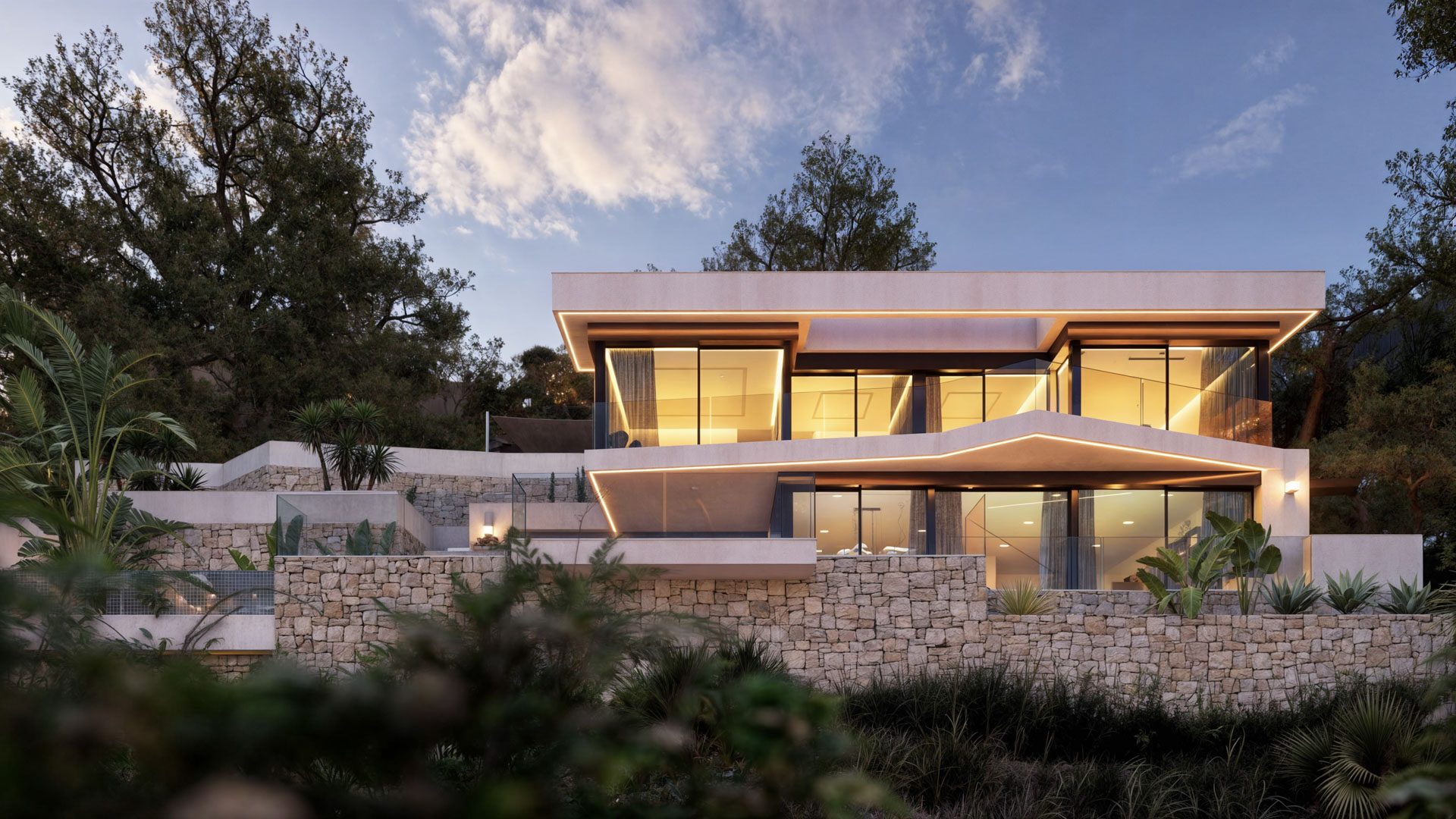 Vue extérieure de la villa à plusieurs niveaux avec murs en pierre naturelle, éclairage LED intégré et larges façades vitrées s'intégrant dans le terrain en pente.