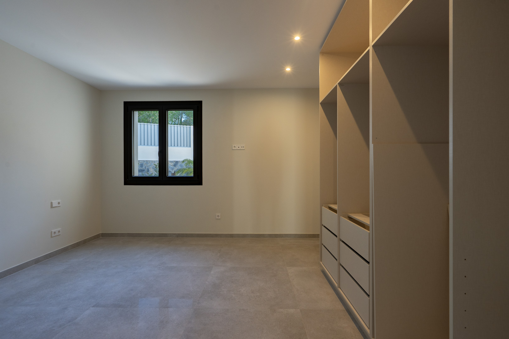 Intérieur lumineux avec placard intégré et fenêtre à cadre noir.