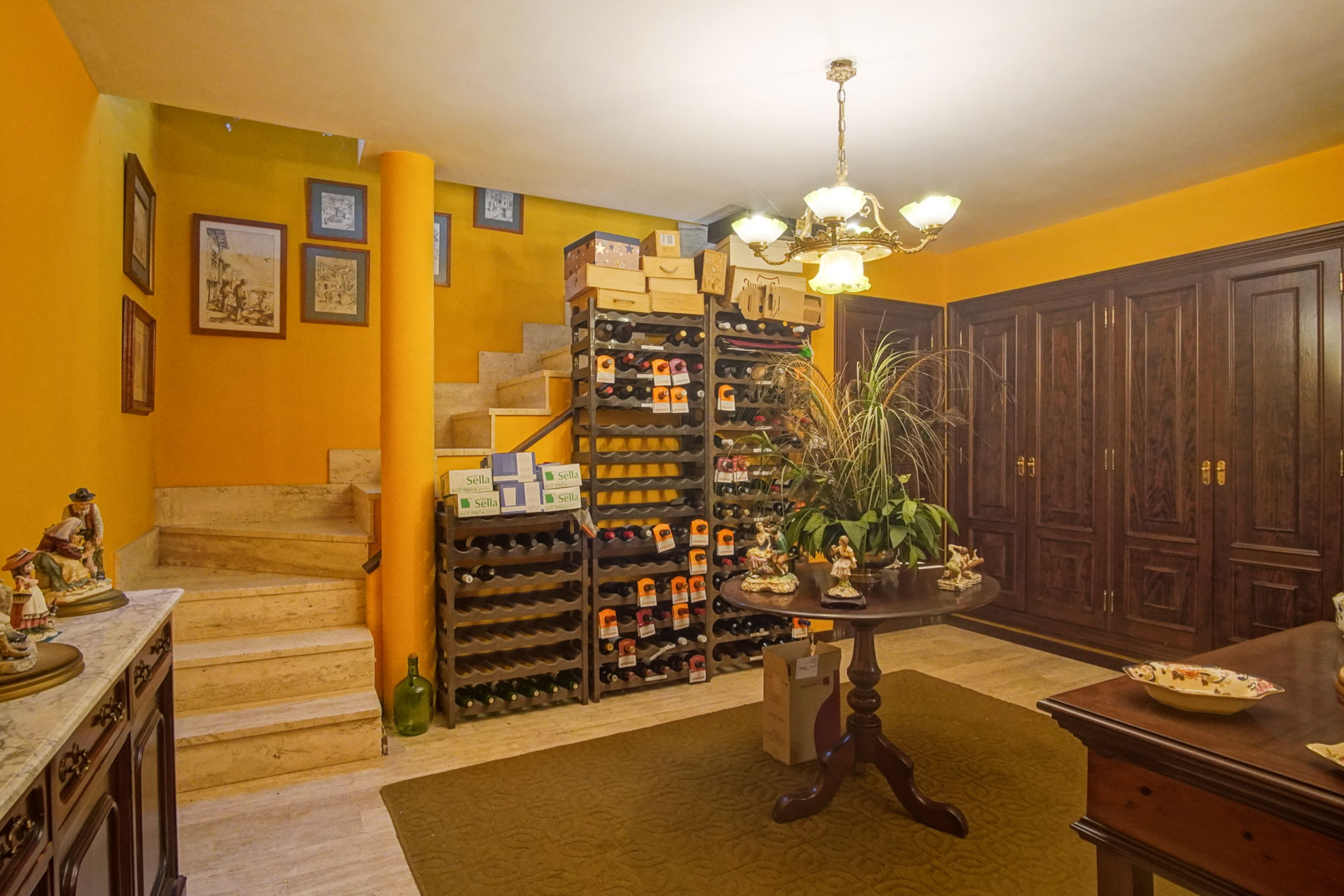 Cave à vin au sous-sol avec escalier en marbre, étagères de rangement et grands placards en bois massif intégrés.
