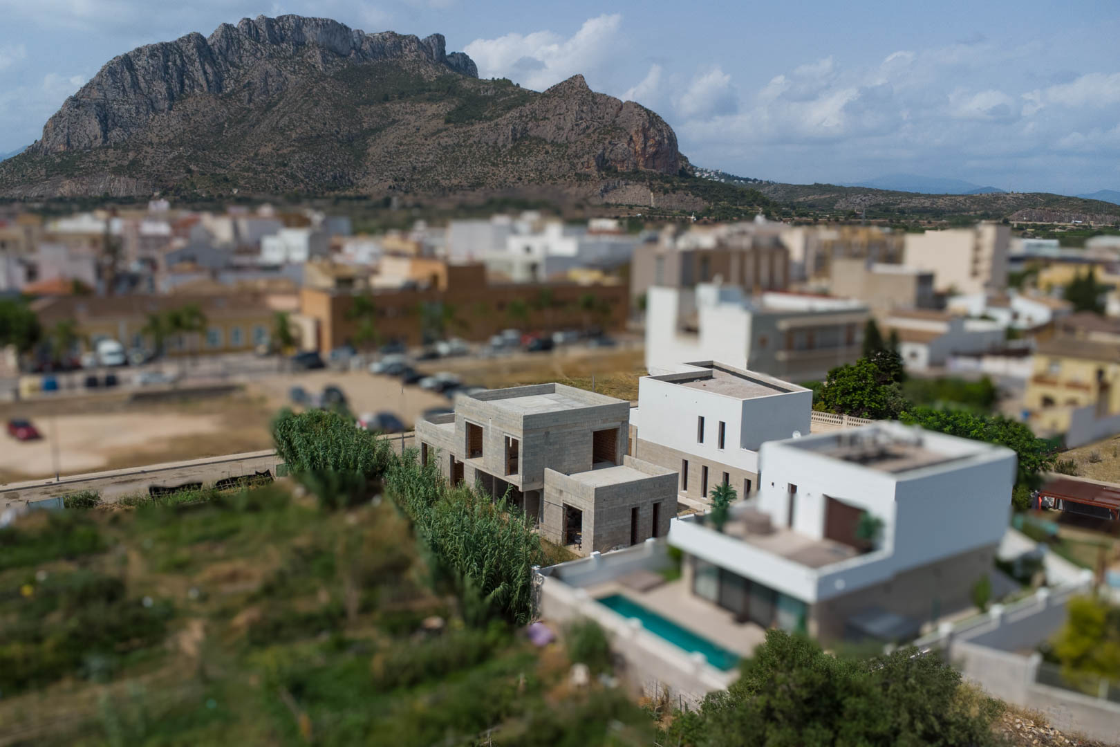 Vue aérienne de trois villas modernes en construction à El Vergel, mettant en valeur leur architecture cubique face à la montagne Segaria.